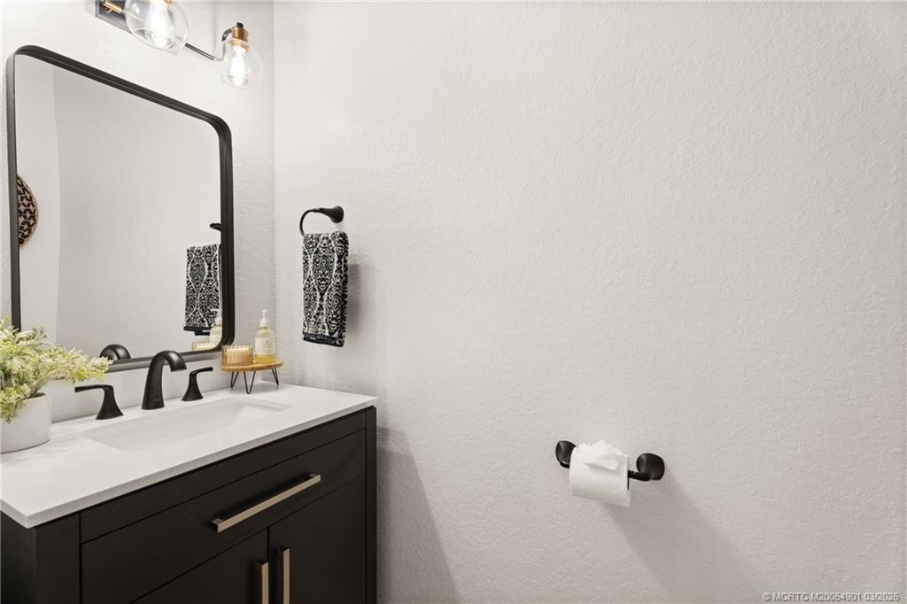 2973 Southwest Porpoise Circle Stuart, FL 34997 - Photo 32 of 47 a bathroom with a sink and a mirror