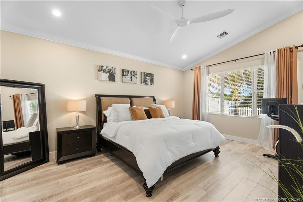 2973 Southwest Porpoise Circle Stuart, FL 34997 - Photo 34 of 47 a bedroom with a large bed and a tv