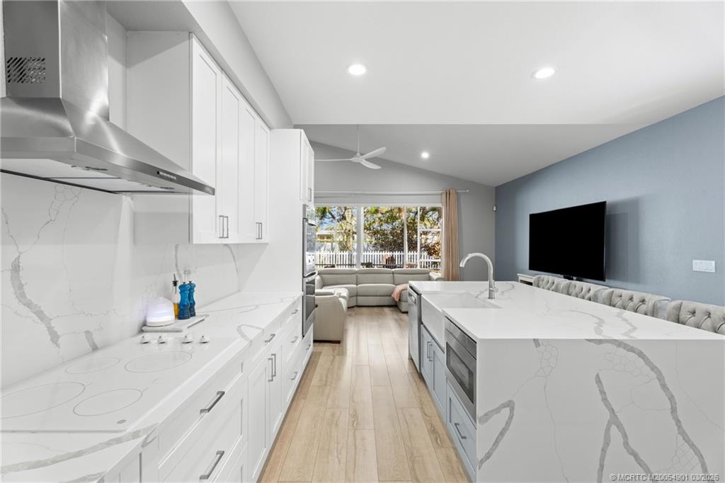 2973 Southwest Porpoise Circle Stuart, FL 34997 - Photo 7 of 47 a large white kitchen with a stove a sink and a large window