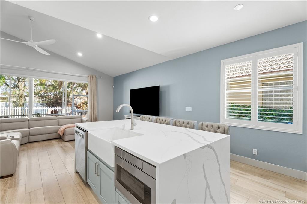 2973 Southwest Porpoise Circle Stuart, FL 34997 - Photo 10 of 47 a view of center island a sink a wooden floor and a large window