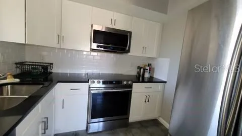 a kitchen with a sink stove and microwave