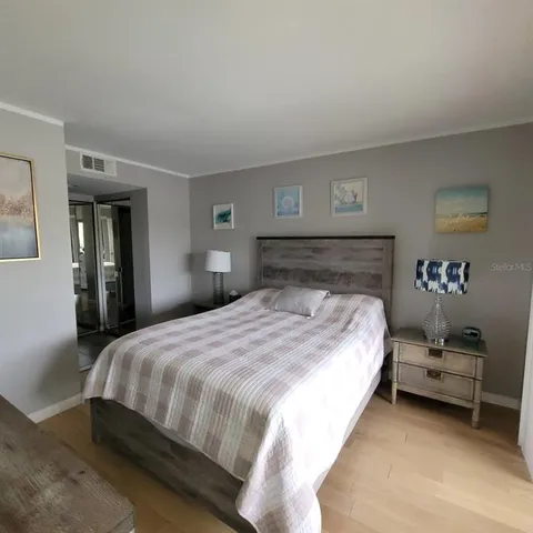 a bedroom with a bed and a lamp on dresser