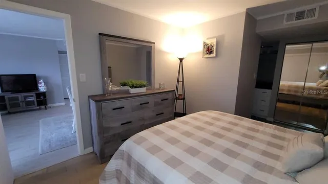 a bedroom with a bed and a flat screen tv