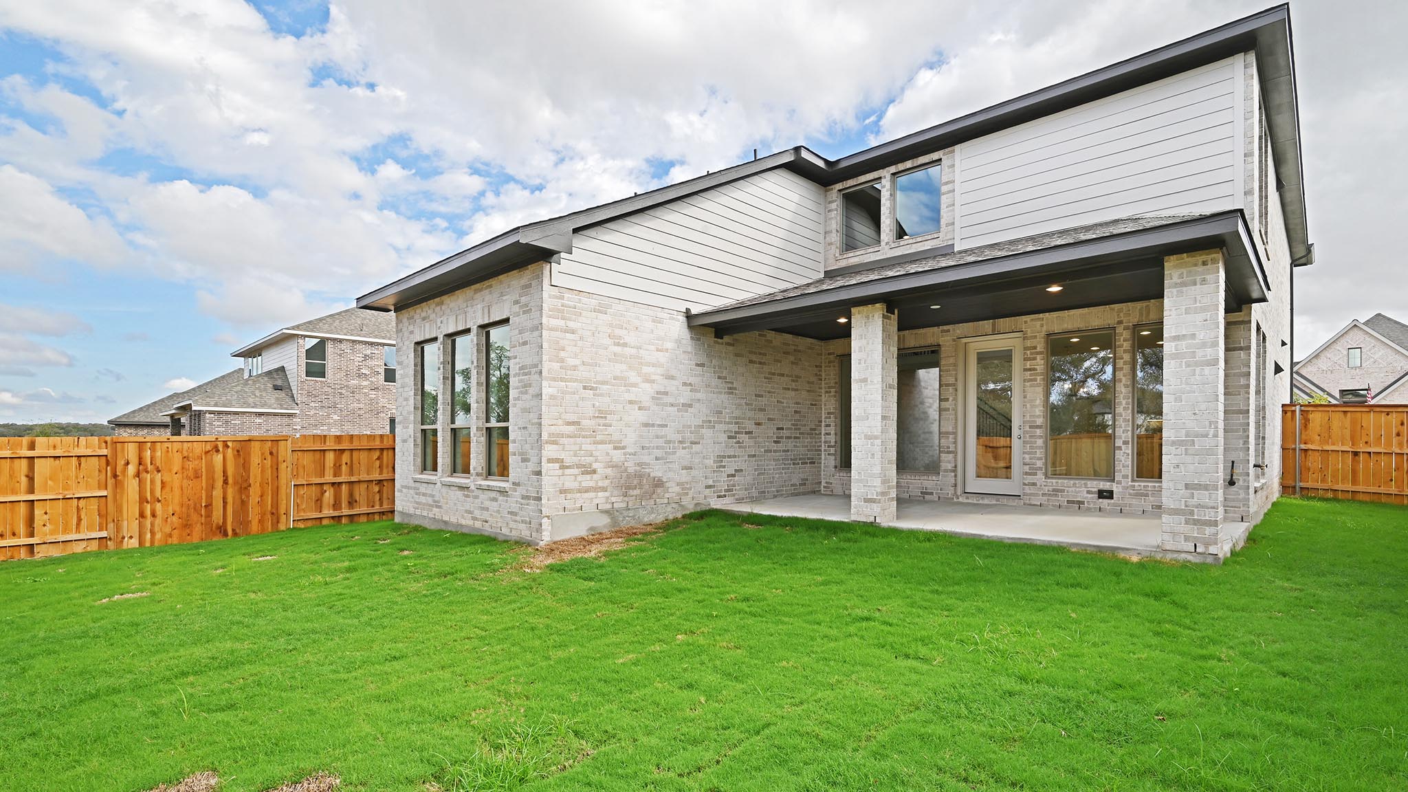 338 Prickly Poppy Loop Kyle, TX 78640 - Photo 12 of 40 Back of property featuring a fenced backyard, a patio area, and brick siding