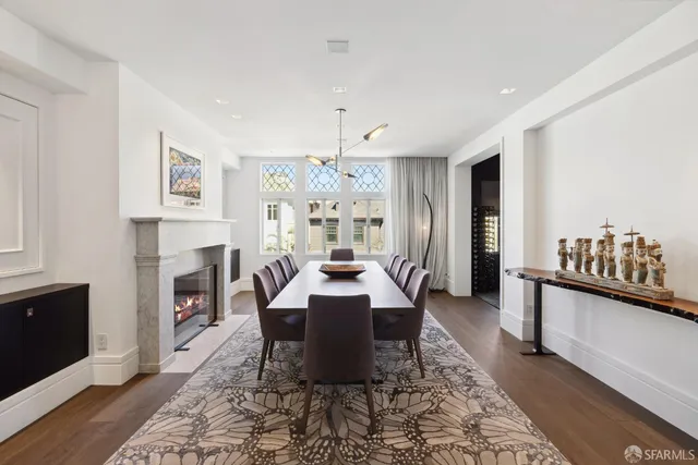 a dining room with wooden floor and a fireplace