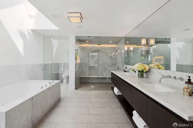 a large bathroom with a double vanity sink large mirror and a bathtub