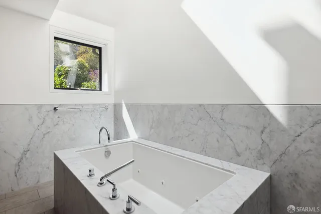 a bathroom with a tub sink and mirror