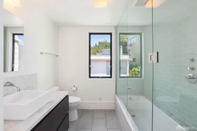 a bathroom with a tub a sink and a window