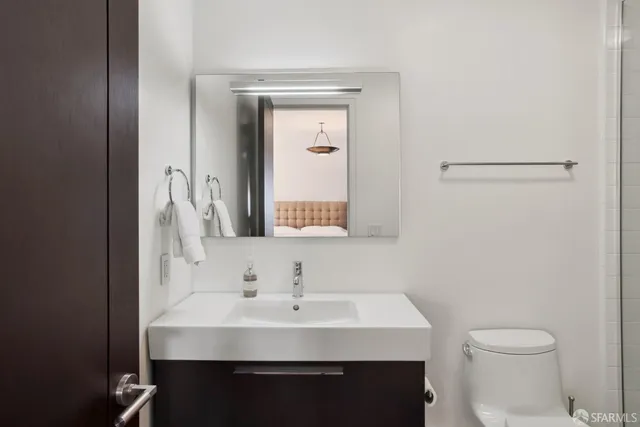 a bathroom with a sink a toilet and mirror