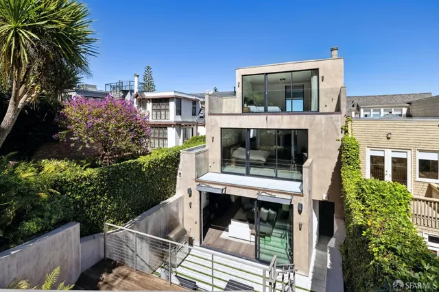 a living room with a fireplace and a potted plant