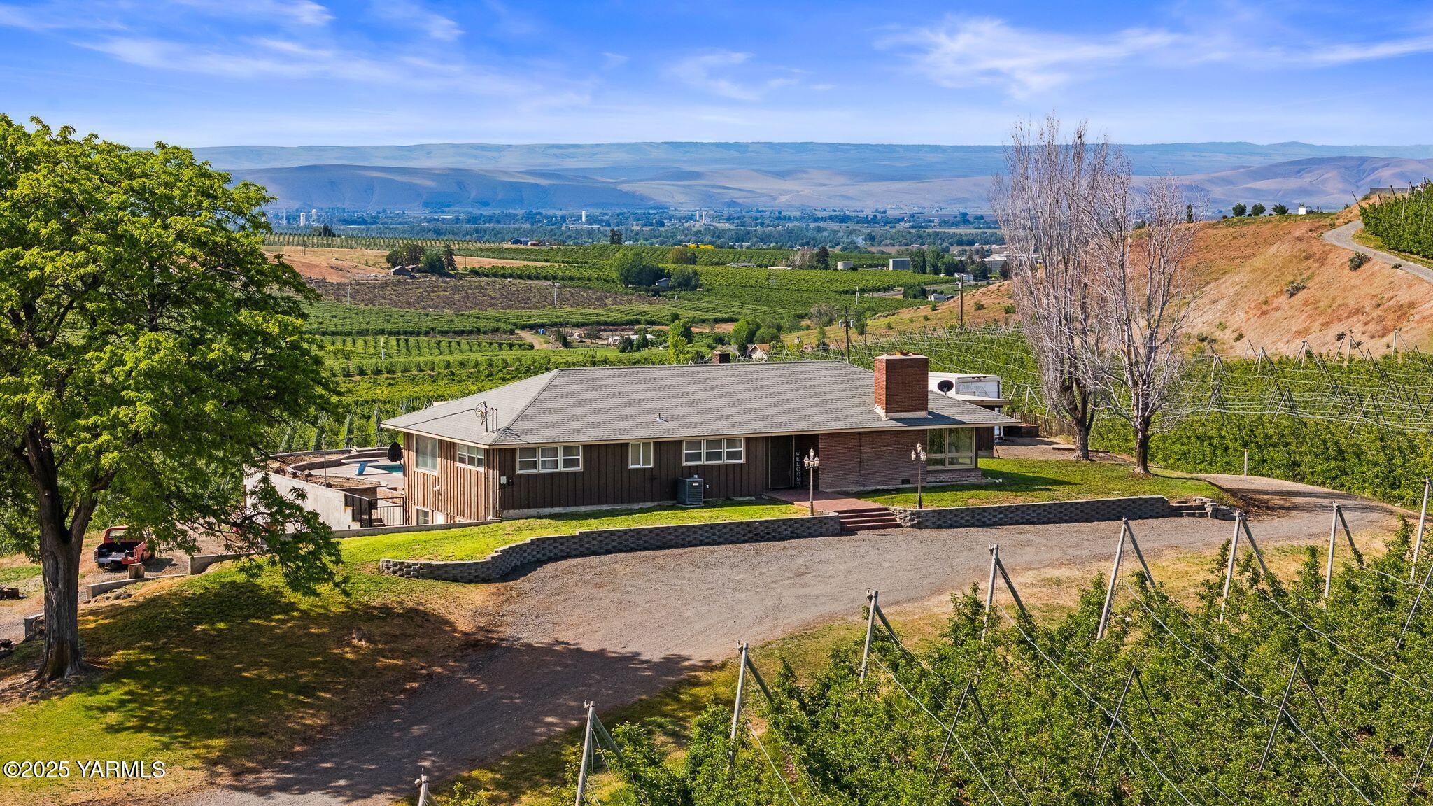3090 Lombard Loop Road Wapato, WA 98951 - Photo 1 of 44 a view of a city with lawn chairs and a large tree