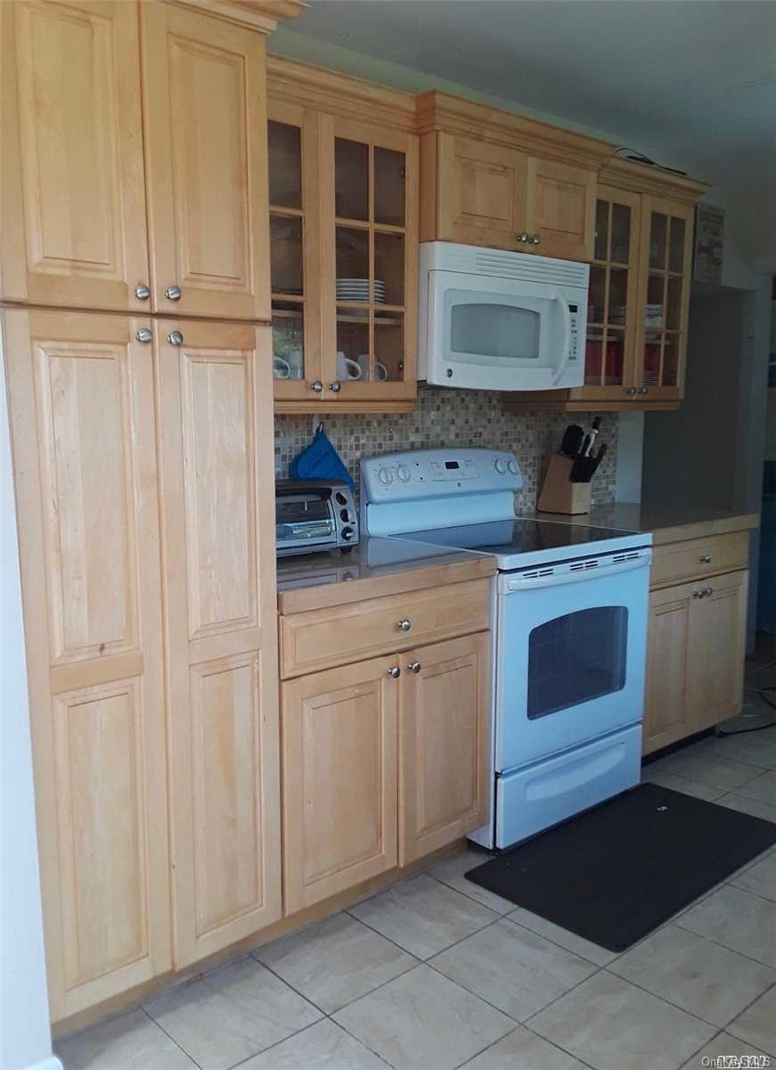 49 Surf Ocean Beach, NY 11770 - Photo 2 of 12 a kitchen with stainless steel appliances white cabinets and a sink