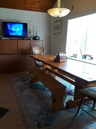 a room with a table chairs and a flat screen tv