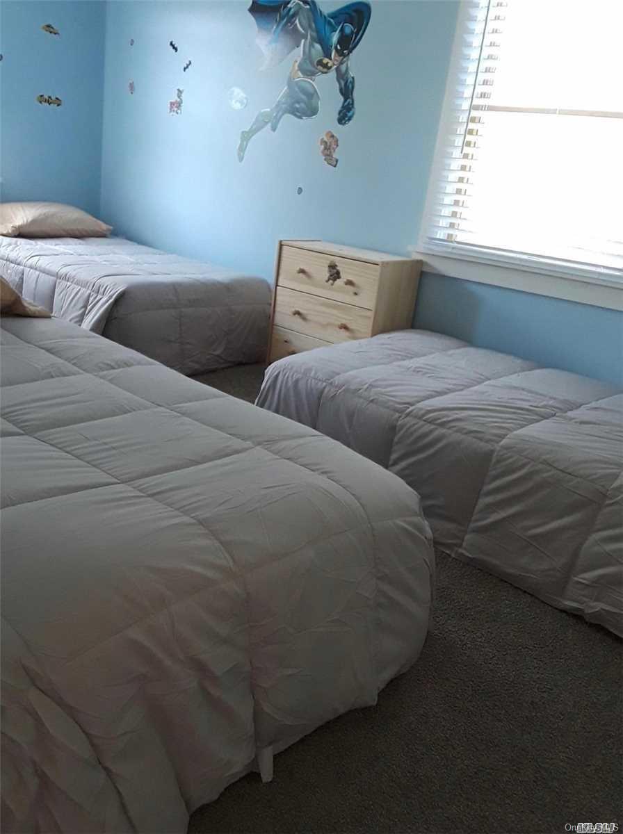 49 Surf Ocean Beach, NY 11770 - Photo 6 of 12 a bedroom with two beds and a window