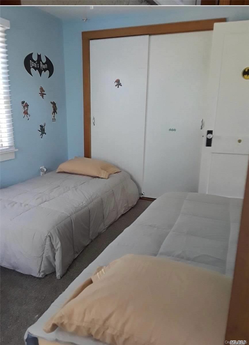 49 Surf Ocean Beach, NY 11770 - Photo 7 of 12 a bedroom with a bed and a window