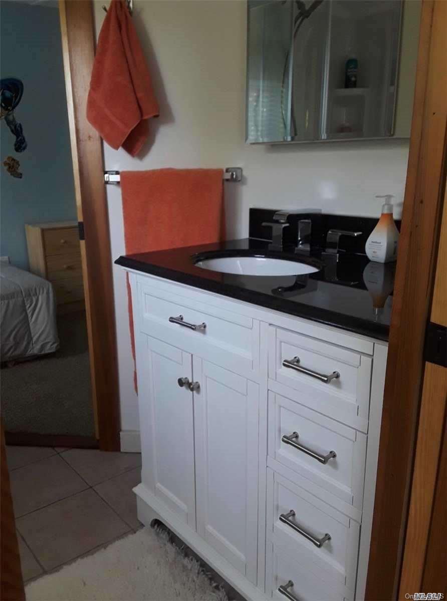 49 Surf Ocean Beach, NY 11770 - Photo 10 of 12 a kitchen with white cabinets and sink