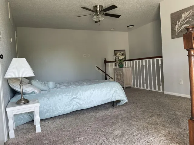 a bedroom with a bed and a lamp on the wall