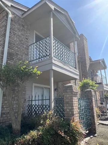 a front view of a house with a tree