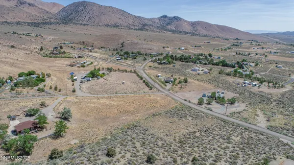 a view of a dry field with mountains in the background