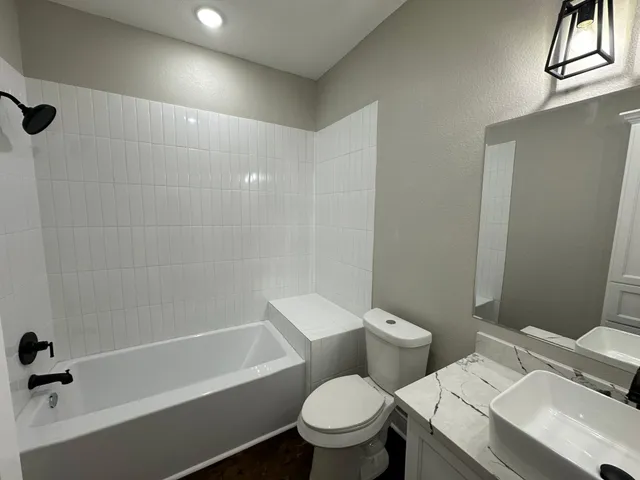 a white toilet sitting next to a bath tub