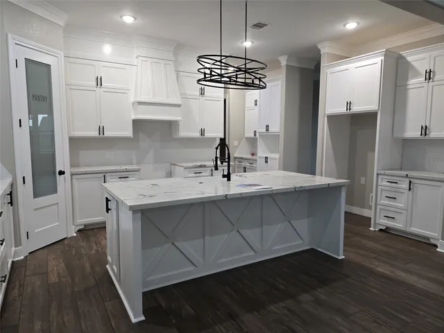 a kitchen with stainless steel appliances a sink stove and wooden floor
