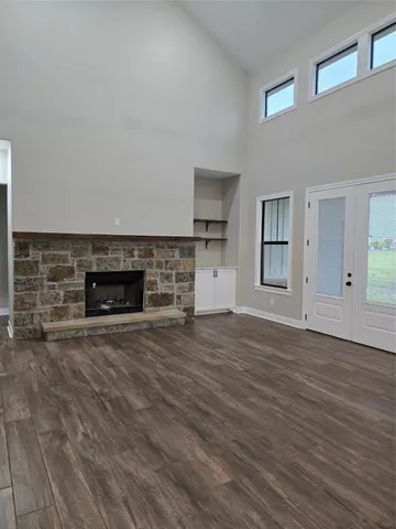 a view of empty room with wooden floor and fireplace