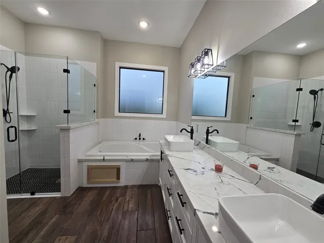 a bathroom with a double vanity sink a mirror and a bathtub