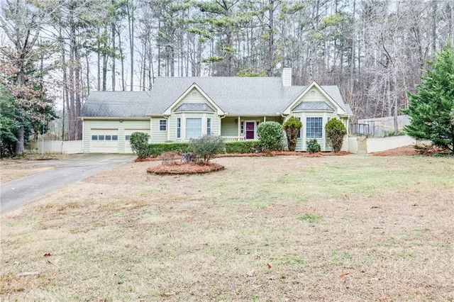 a front view of a house with a yard and trees