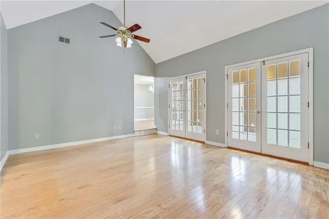 a view of an empty room with a window and wooden floor