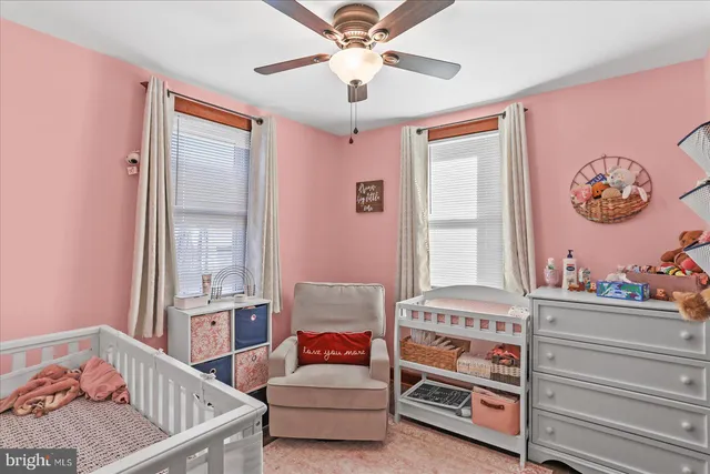 a bedroom with furniture and a chandelier fan