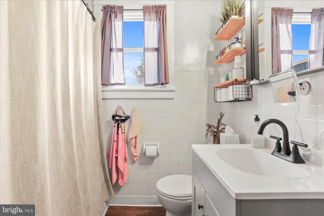 a bathroom with a sink vanity mirror and toilet