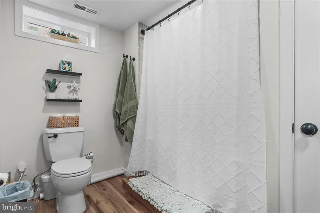 a white toilet sitting next to a shower curtain