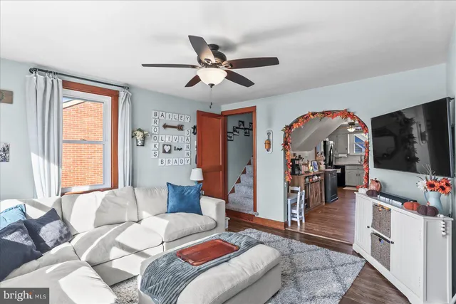 a living room with furniture a flat screen tv and a window