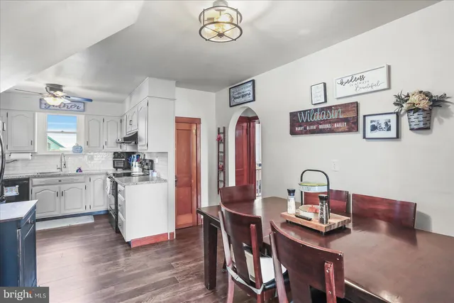 a view of a dining room with furniture a chandelier and wooden floor
