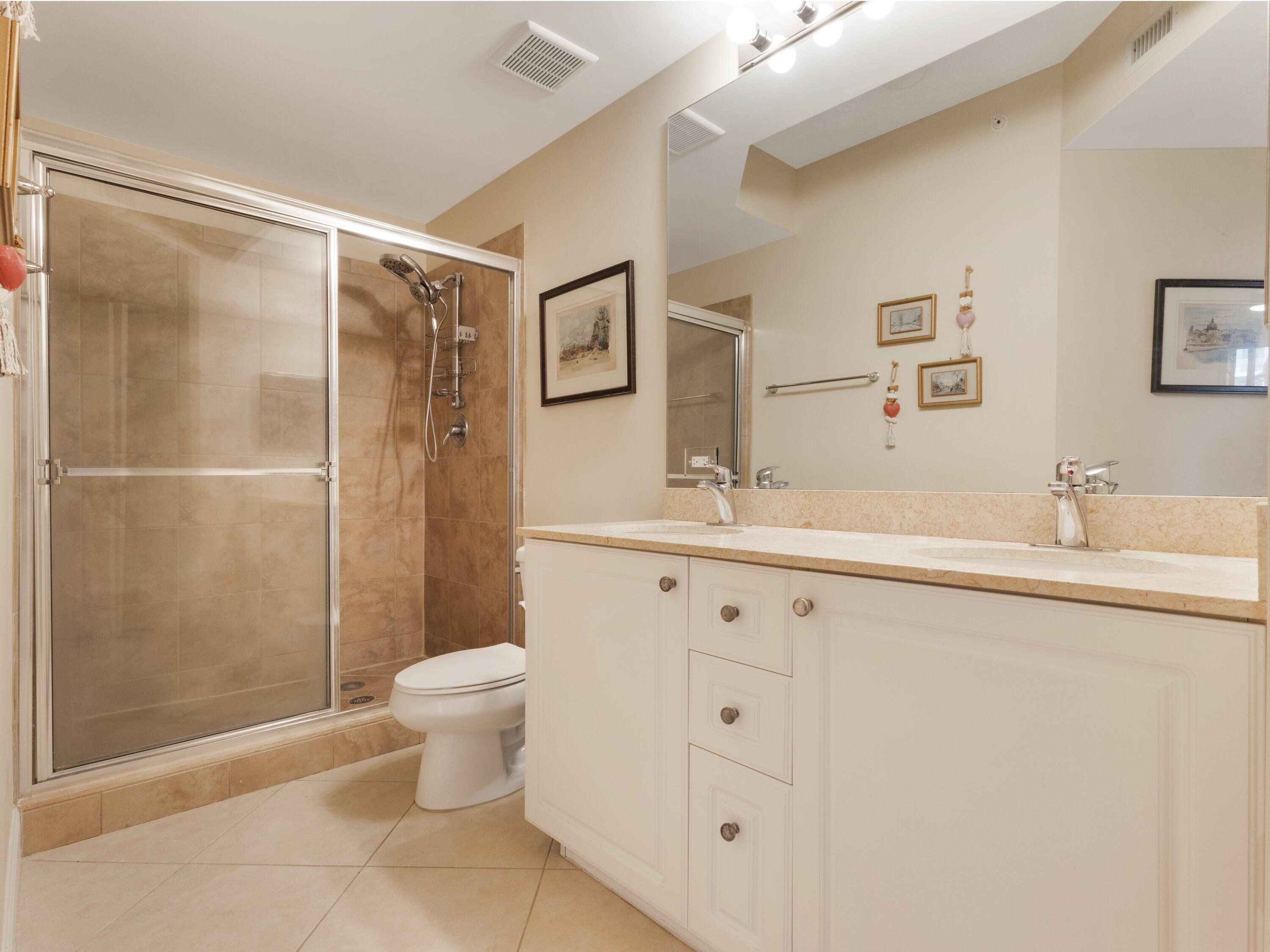 1690 Renaissance Commons Boulevard, Unit 1412 Boynton Beach, FL 33426 - Photo 23 of 49 a bathroom with a sink toilet and shower