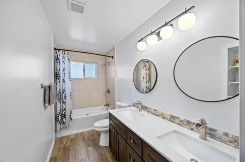 a bathroom with a double vanity sink mirror and shower