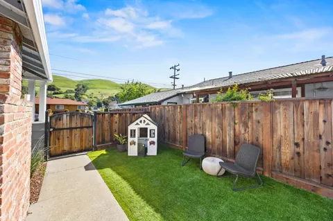 a view of a backyard with a garden and outdoor seating