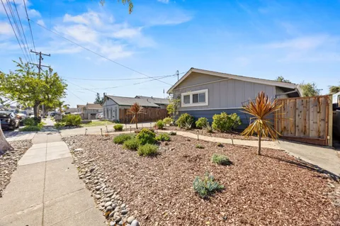 a view of a house with a yard and potted plants