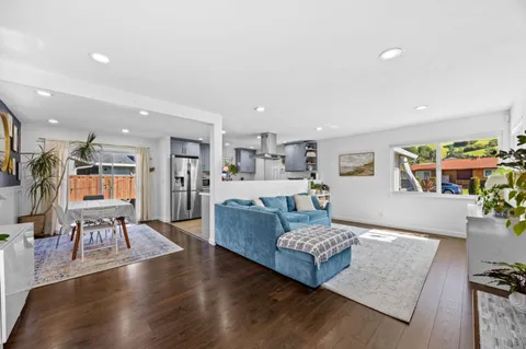 a living room with furniture and wooden floor