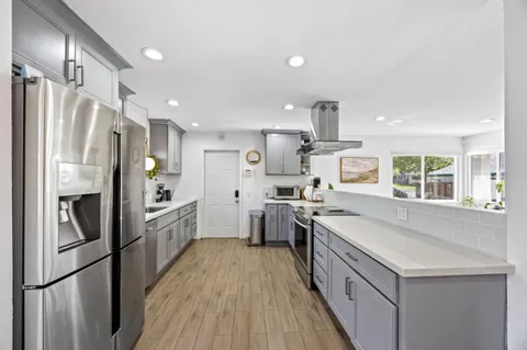 a kitchen with stainless steel appliances a refrigerator sink and cabinets