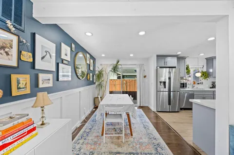 a living room with stainless steel appliances furniture and a view of kitchen
