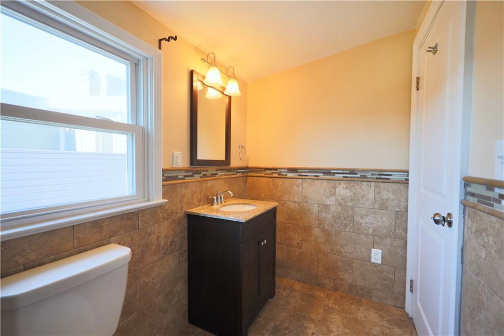 513 Lockhart Street, Unit 2 Pittsburgh, PA 15212 - Photo 18 of 21 a bathroom with a granite countertop sink a toilet and a shower