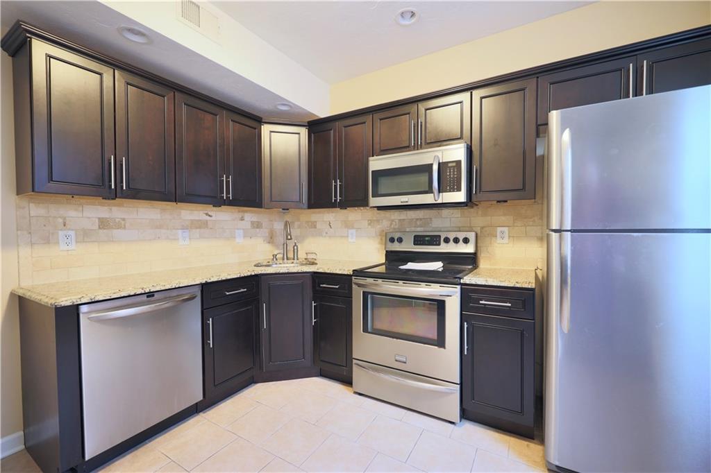513 Lockhart Street, Unit 2 Pittsburgh, PA 15212 - Photo 8 of 21 a kitchen with stainless steel appliances granite countertop a refrigerator stove a sink and dishwasher