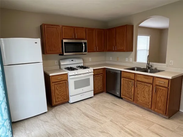 a kitchen with stainless steel appliances granite countertop a refrigerator and a stove top oven