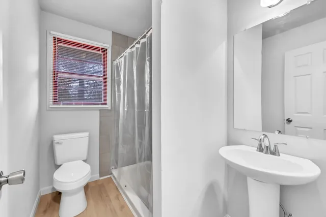 a bathroom with a toilet sink a mirror and shower