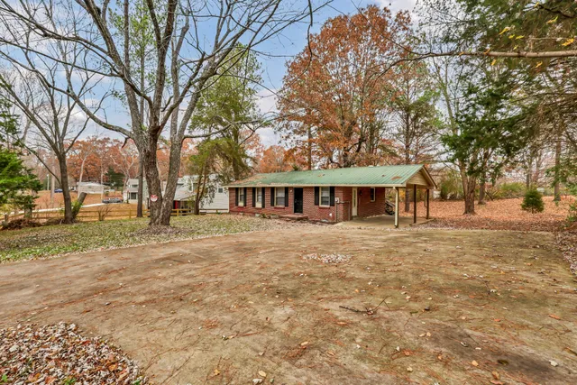 a view of a house with a large tree and a big yard