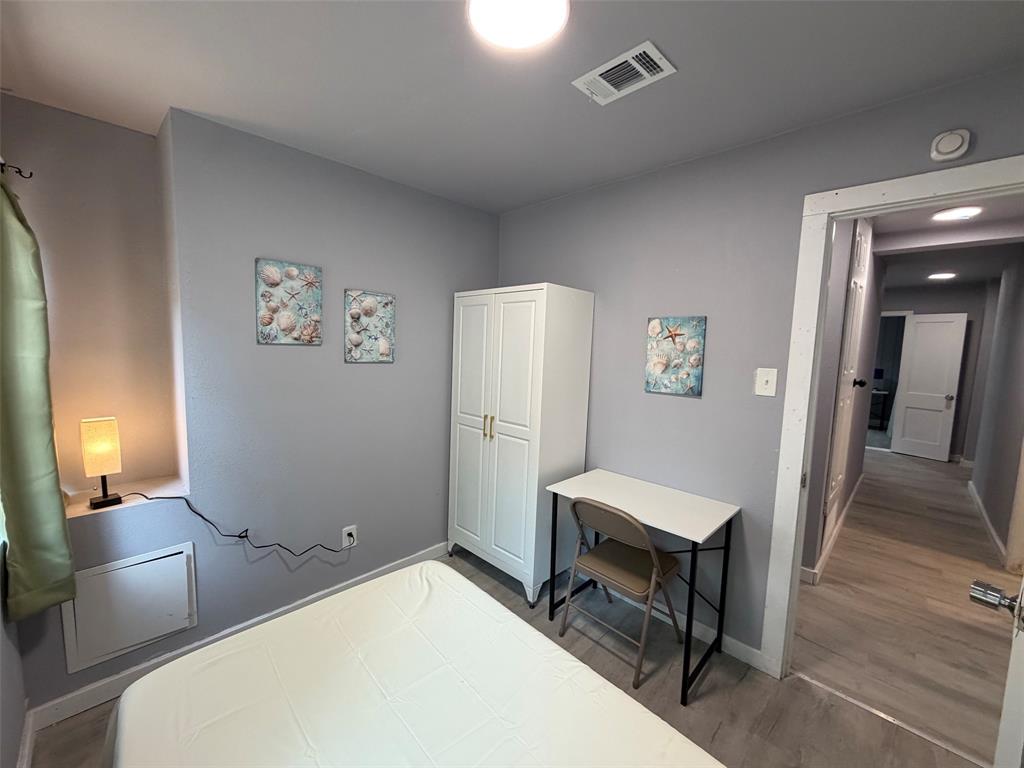 714 Southwest Dallas Street Grand Prairie, TX 75051 - Photo 13 of 27 Room featuring light gray walls, recessed window nook, and wood-finish flooring