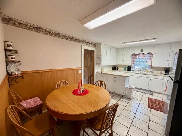 a kitchen with a sink a stove a refrigerator and white cabinets