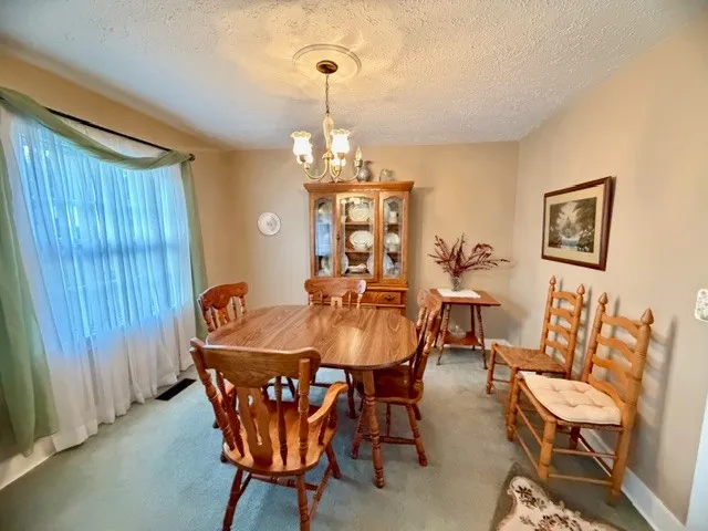 a view of a dining room with furniture and chandelier
