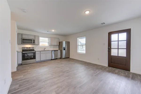 a view of a kitchen with a sink stove cabinets and empty room
